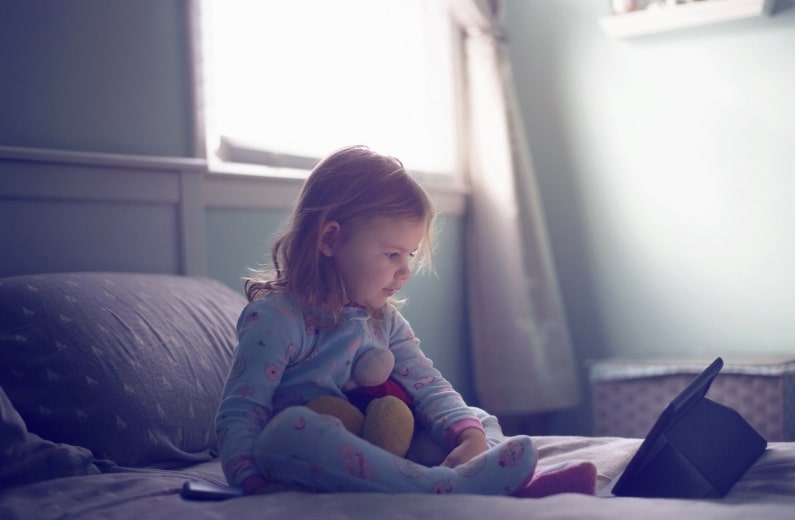ベッドの上で起き上がる子ども