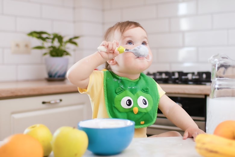 スプーンでヨーグルトを食べる子ども