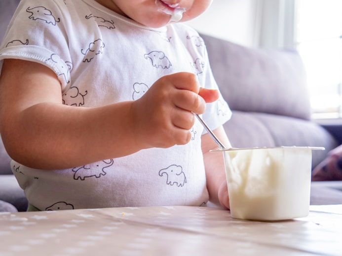 スプーンでヨーグルトを食べる子ども