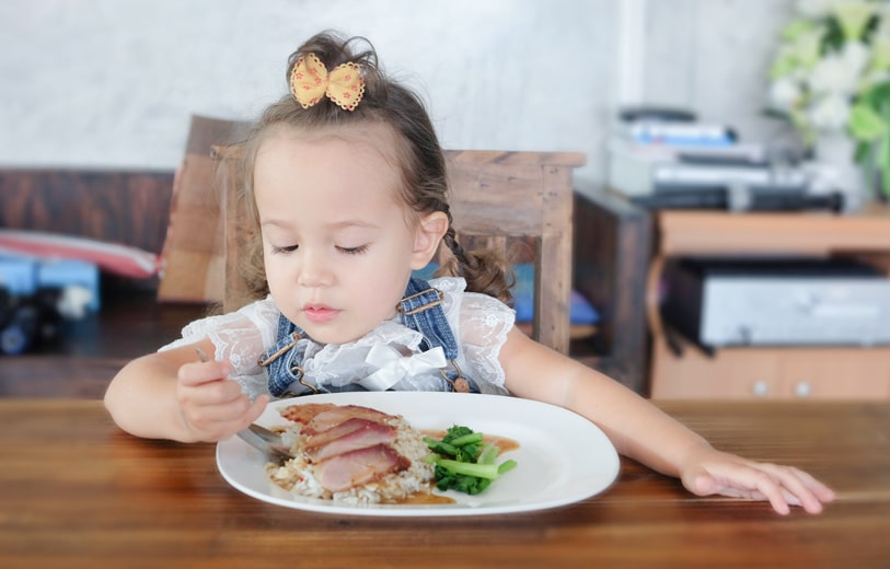 スプーンでご飯を食べる子ども
