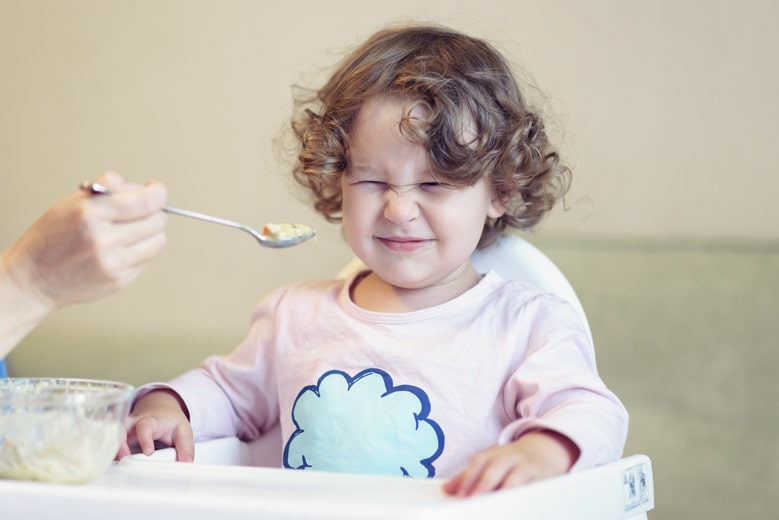 食事中に苦笑いをする子ども