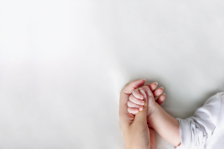 子どもの手を握る母